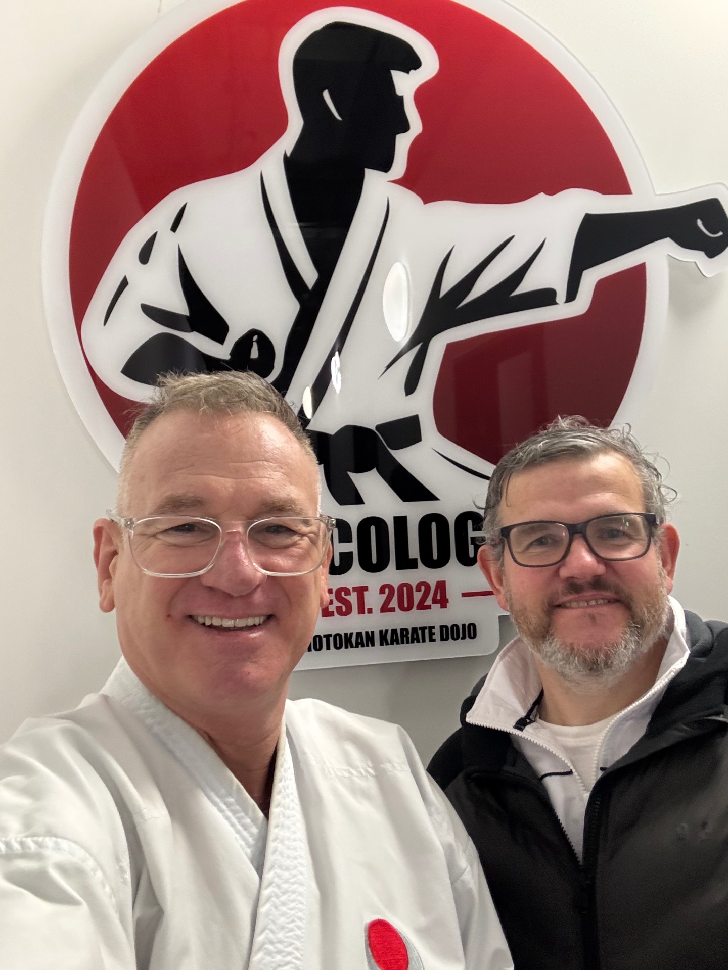 Martin Buchstaller mit Trainingspartner vor dem JKA Cologne Logo