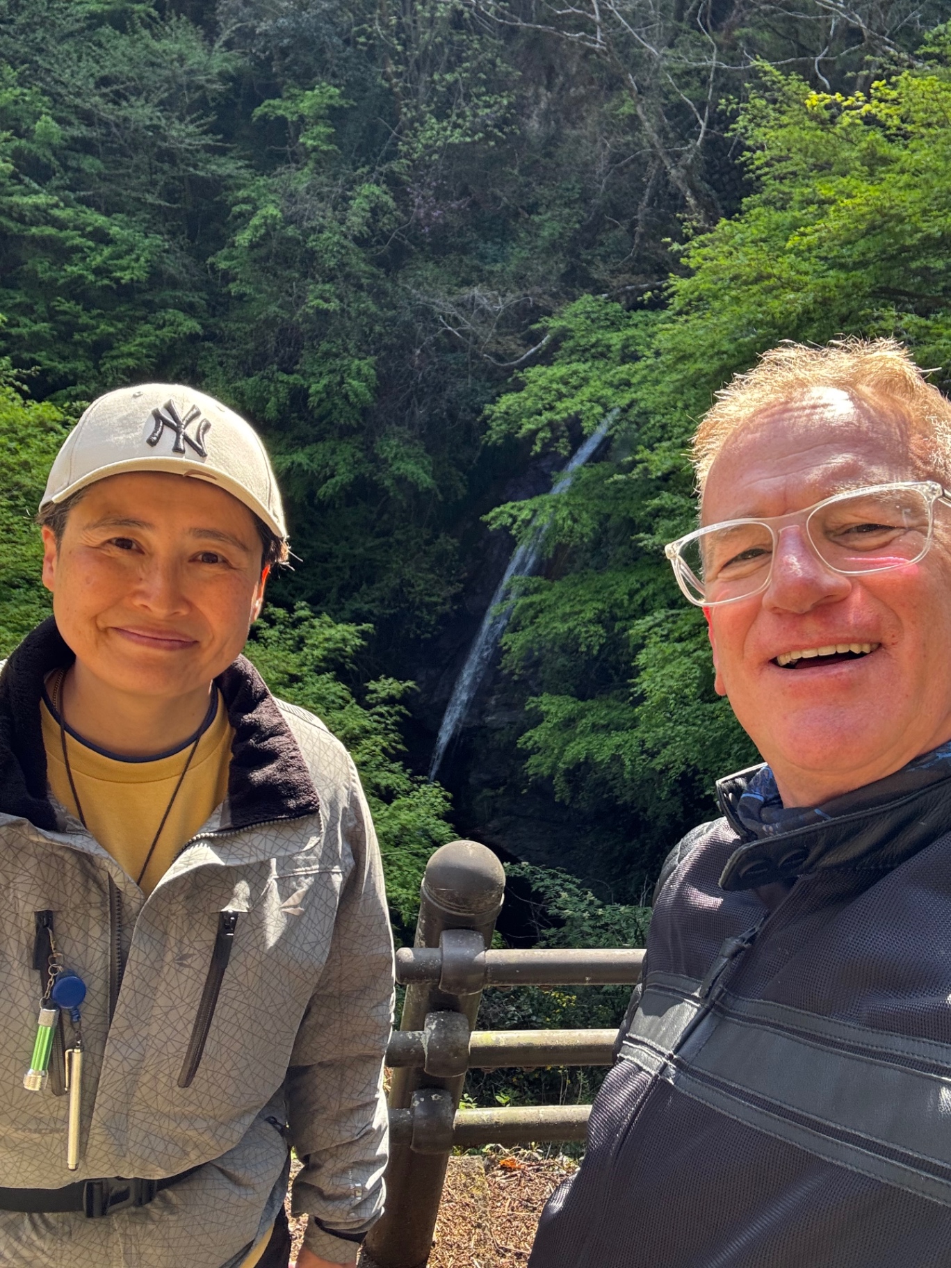 Selfie vor einem Wasserfall im dichten grünen Wald in Japan