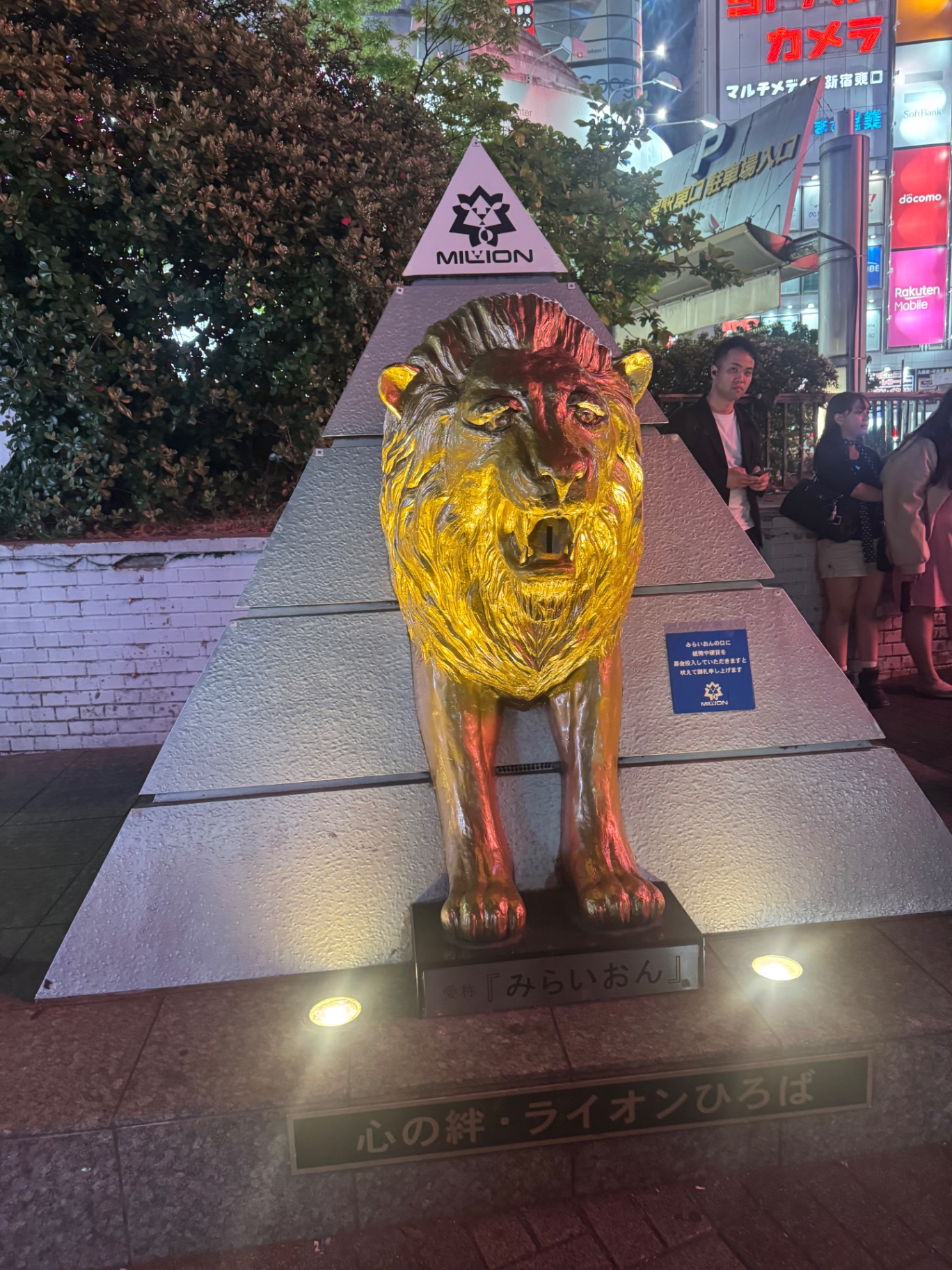 Beleuchteter Löwe vor neonbunten Schildern in Tokio bei Nacht